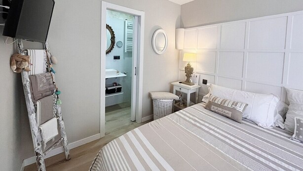 Une chambre d’hôtel avec un lit, une table de chevet, une lampe et un miroir.
