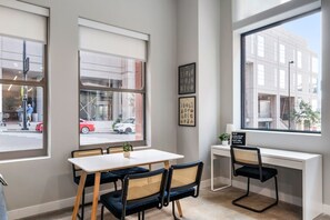 A modern room with a large window, a desk, and two chairs. - 2 Bedroom Near UC & Good Samaritan Hospital + Wifi (Cincinnati)