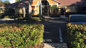 A building with a yellow facade, a clock tower, and a parking lot. - Florida Vibes - A Fort Myers Gem- 2 Bedroom Condo.

 (Fort Myers)
