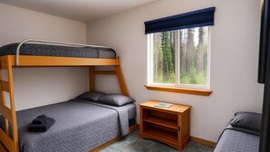 A bunk bed room with a window, a small wooden shelf, and a tiled floor. - Kenai Fishing Cabin | Kitchen + Fire Pit (Kenai)