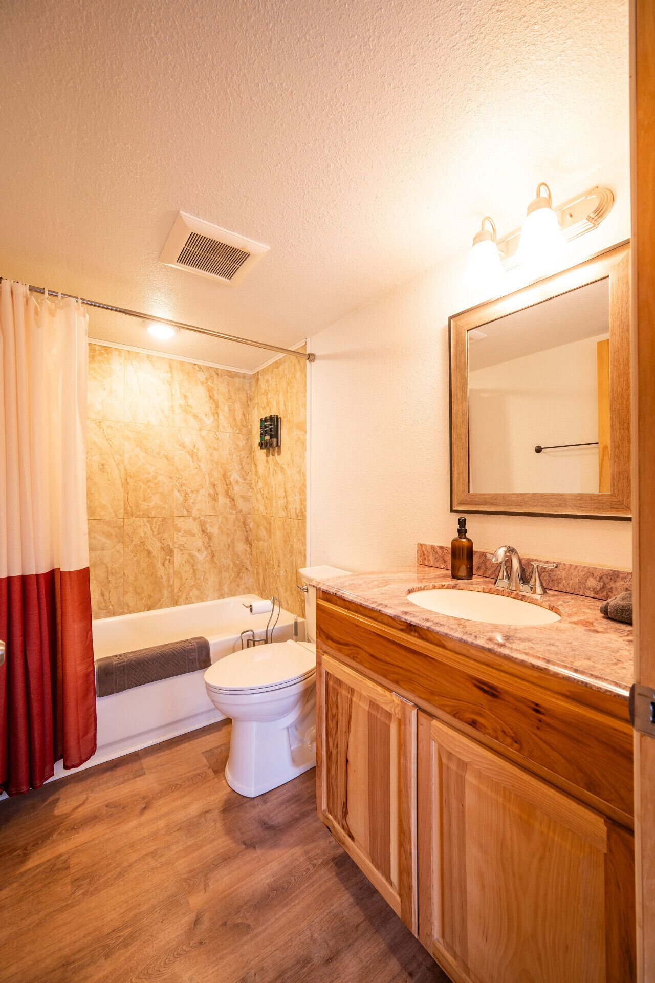 Un baño con bañera, inodoro y lavamanos.