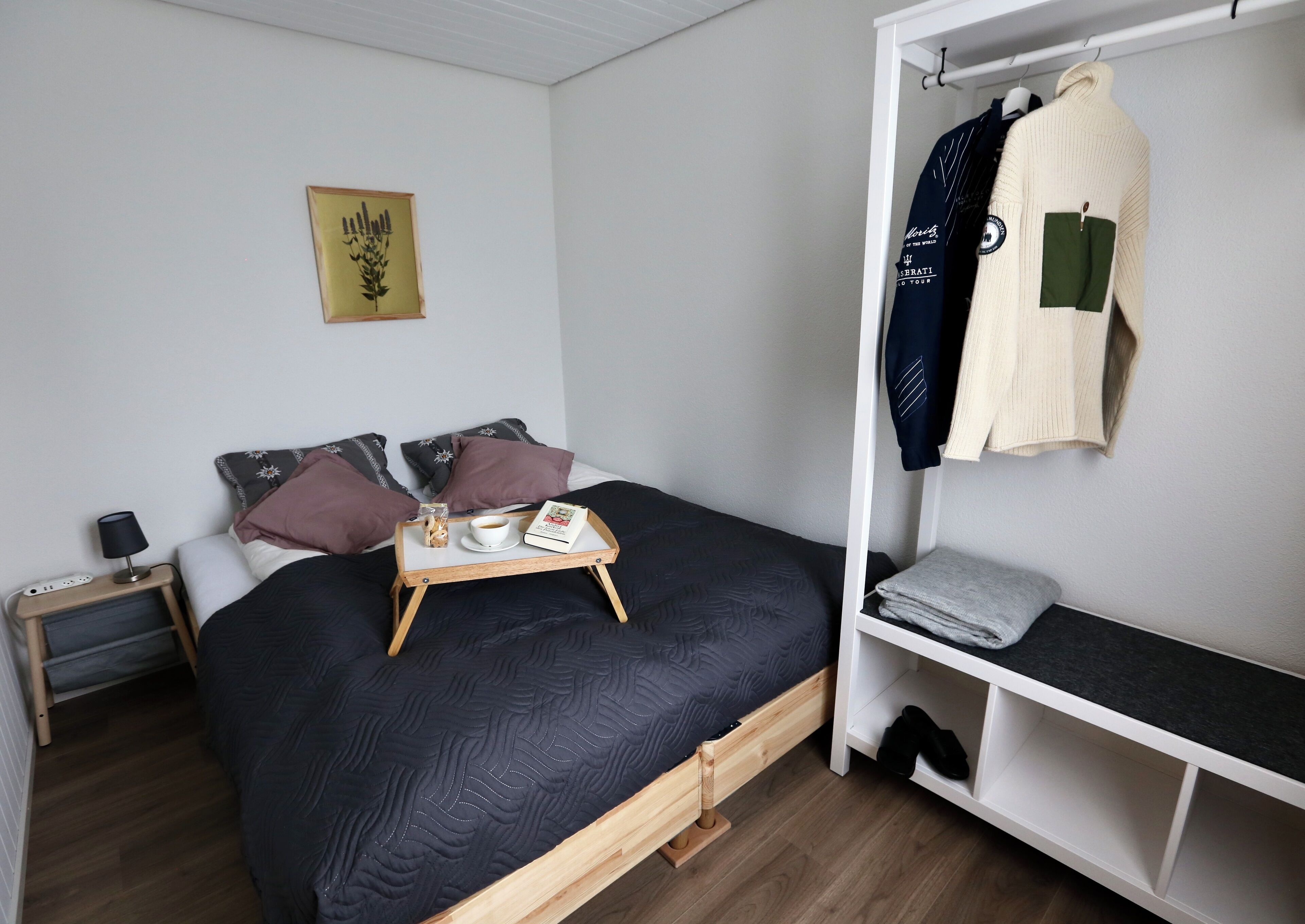 Une chambre à coucher avec un lit, une table de chevet et une armoire.