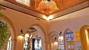 A spacious lobby with a high, ornate ceiling and a chandelier. There are potted plants and a reception desk with a sign. - Mazar Resort & Spa By Kemet (Sharm El Sheikh)