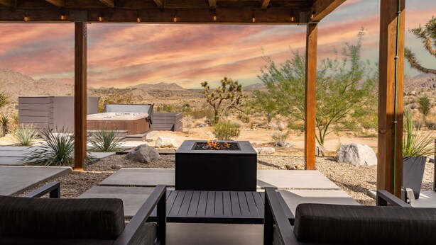 Un patio al aire libre con un brasero, asientos y vistas al paisaje desértico.