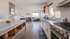 Una cocina moderna con una isla grande, horno empotrado y amplia encimera.
