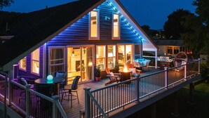 Et moderne hus med terrasse, udendørs møbler og grillområde.