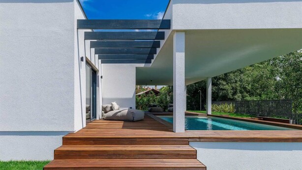 Un espace piscine extérieur moderne, agrémenté d’un escalier en bois menant à un espace détente abrité.