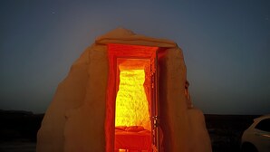 Una iglú con una entrada abierta, mostrando un interior cálido.