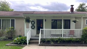 A single-story house with a front porch, a chimney, and a small garden area. - Private Home Near I71, Snow Trails, Golf & Race Tracks (Mansfield)