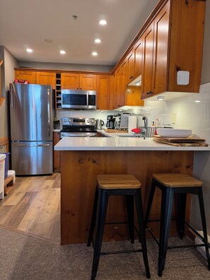 Enjoy cooking in this well-equipped kitchen with a central island, stainless steel appliances, and ample cabinetry.
