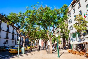 A tree-lined street with outdoor seating and buildings on either side. - Funchal Essence by Atlantic Holiday (Funchal)