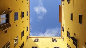 Ein gelbes Gebäude mit vielen Fenstern und Klimaanlagen.