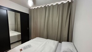 Ein Hotelzimmer mit einem Bett, einem Deckenventilator und einem großen Spiegel.