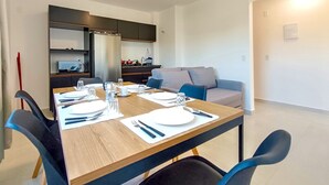 A modern dining area with a wooden table set for four, surrounded by blue chairs.