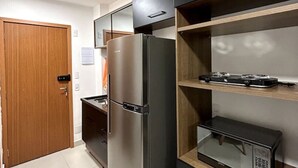 A modern kitchen with a stainless steel refrigerator, a microwave, and a built-in oven. - Studio 603 - proximo ao metro Santana - SP (São Paulo)