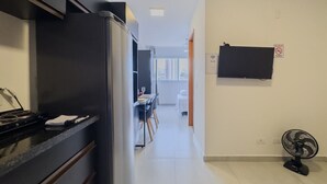 Eine Küche mit Herd, Kühlschrank und Essbereich inklusive Stühle und Tisch.