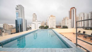 Ein Dachpool mit Blick auf die Stadtlandschaft, umgeben von Hochhäusern.