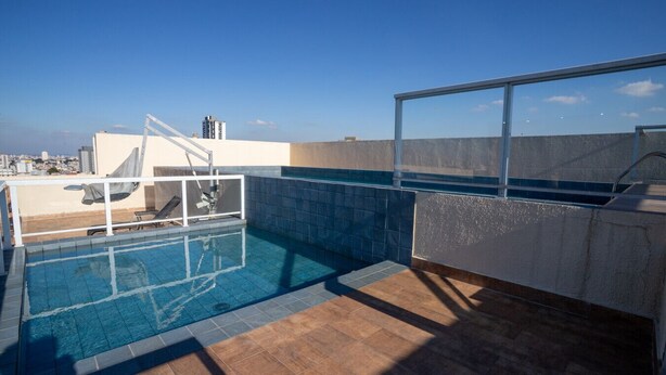 A rooftop swimming pool with a clear view of the city skyline.