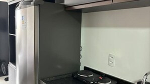 Una cocina moderna con refrigerador empotrado, estufa y lavaplatos.