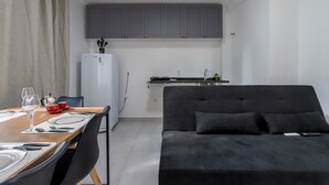 A compact living space with a dining area, kitchenette, and a sofa. - Apto 502 - 2 dorm em Santana (São Paulo)