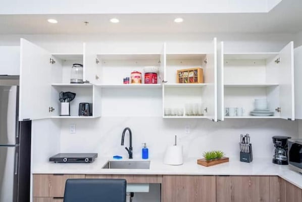 A compact kitchen with white cabinetry, a built-in sink, and a coffee machine. - King Bed 2B/2Ba Oasis minutes to Brickell 6 guests (Miami)