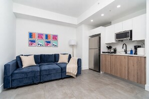 Una cocina moderna con microondas integrado, refrigerador y encimera de madera.