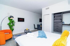 A modern hotel room with a bed, a desk, a chair, a TV, and a wardrobe. - King Bed brand new safe Oasis minutes to Brickell (Miami)