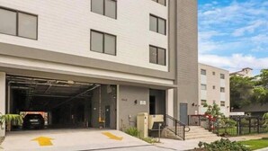 Un bâtiment moderne avec une entrée de garage, un escalier et un ciel dégagé.