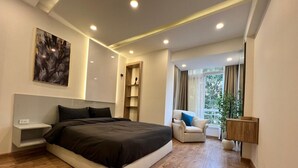 A modern bedroom with a large bed, bedside tables, a chair, and a nightstand.