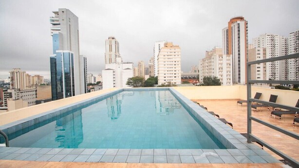 Ein Pool auf dem Dach mit Blick auf die Stadtlandschaft, umgeben von Hochhäusern.
