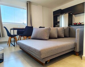 Una sala de estar moderna con un sofá, una mesa de comedor y sillas.
