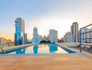 A rooftop pool with a cityscape view, surrounded by high-rise buildings.