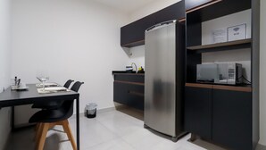 Una cocina compacta con refrigerador, microondas y una pequeña encimera.