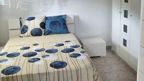 A bedroom with a bed, a bedside table, a wardrobe, and a ceiling fan. - BEAUTIFUL 1ST-FLOOR VILLA APARTMENT (Sainte-Anne)
