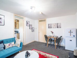 A compact living space with a kitchenette, a dining area, and a sofa. - Blissful Apartment. Family-Friendly and work suited... HOME AWAY FROM HOME (Sheffield)