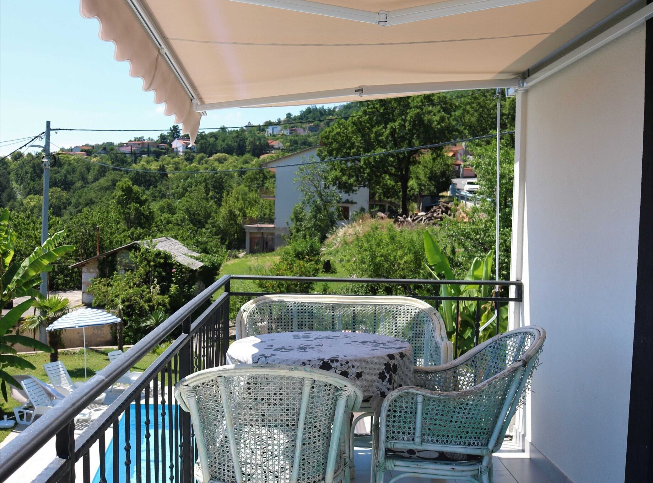 A balcony with wicker furniture and a pool.