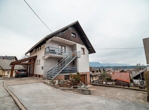 A two-story house with a balcony and a staircase leading to the upper floor. - Quiet and Sunny Apartment with Balcony - Two Bedroom Apartment with Balcony (Podnart)