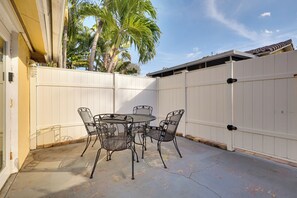 A patio with a round table and four chairs, a white fence, and a palm tree. - Detached Backyard Studio in Fort Lauderdale! (Fort Lauderdale)