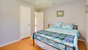 Quarto com cama, ventilador de teto e porta.