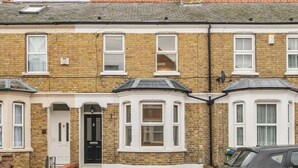 A row of terraced houses with a black car parked in front.