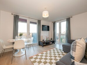 Relax in a stylish living room with a dining area, comfortable sofa, and flat-screen TV.