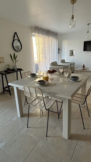 Un comedor con una mesa larga, sillas y algunos objetos decorativos.