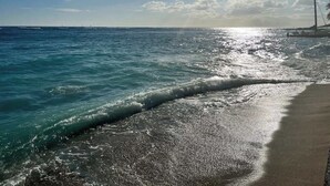 A beach with clear blue water and a sandy shore. - Waikiki Forever Ocean Views, Free Parking & Pool (Honolulu)