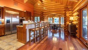 Een interieur van een vakantiehuisje met een keuken, een eethoek en een open haard.