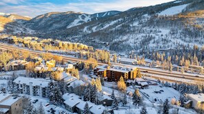 Une ville enneigée, avec des bâtiments et une montagne en arrière-plan.