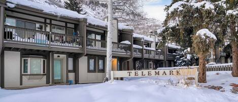 A multi-story building with a balcony and a sign reading "TELEMARK".