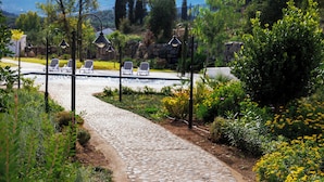 A stone pathway leading to a pool area with lounge chairs and decorative lighting.
