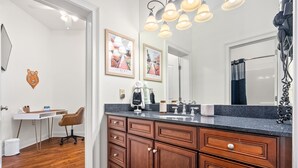 Un baño con tocador de madera, un espejo y un perchero para toallas.