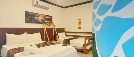 Habitación de hotel con dos camas, un cuadro en la pared y una lámpara en el techo.