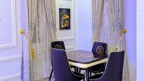 Un coin repas avec une table et des chaises, un lustre et un tableau encadré au mur.